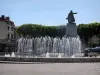Cahors - Springbrunnen des Platzes François-Mitterrand, der Statue von Gambetta, Bäume und Häuser, im Quercy