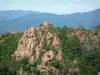 Les Calanques de Piana - Calanche de Piana: Amas rocheux de granit rouge (des calanques) avec des arbres, montagnes en arrière-plan