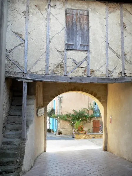 Camon - El porche de entrada del pueblo coronado por una casa de entramado de madera
