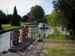 Canal du Midi - Écluse de Montgiscard avec un bateau et canal bordé d'arbres