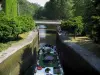 Canal du Midi - Écluse d'Ayguesvives avec un bateau, pont enjambant le canal et arbres