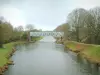 Canal de Nantes à Brest - Canal (rivière) bordé d'arbres, pont et ciel nuageux