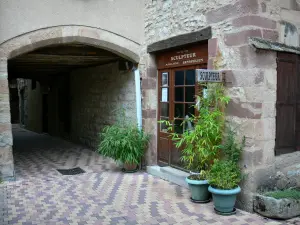 La Canourgue - Porch, front of a sculpture workshop, and shrubs in pots