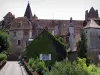 Carennac - Blühende Brücke, Häuser des Dorfes, Kirchturm der Kirche Saint-Pierre, altes Priorat und Schloß Doyens (links), im Quercy