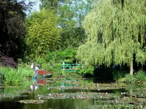 Casa e i giardini di Claude Monet - Giardino di Monet a Giverny: Giardino Acqua: Pond Lily (Lily Pond) punteggiata da ninfee, canne, alberi e vegetazione, Ponte giapponese