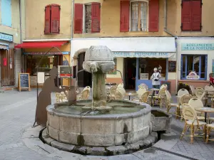 Castellane - The Lions fountain (Mitan street), café terrace, shops and facades of houses in the old town