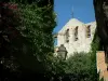 Le Castellet - Bougainvillea (Bougainvillea) in bloei, lamp, wimpels, klimplanten, bomen en de kerk van het middeleeuwse dorp