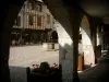 Castelnau-de-Montmiral - Sous les couverts avec vue sur les fleurs, la place de la Mairie (place des Arcades), le puits, les terrasses de cafés et les maisons à pans de bois