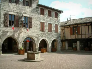 Castelnau-de-Montmiral - Plaza del Ayuntamiento (Place des Arcades), con pozos, el ayuntamiento y las casas de enfrente (ladrillo, piedra o madera con marco)