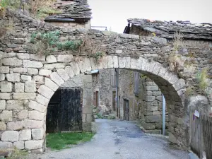 Castelnau-Pégayrols - Porche de piedra y casas de la aldea medieval