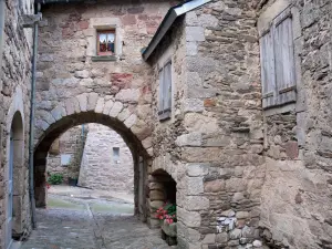 Castelnau-Pégayrols - Porche de piedra y casas de la aldea medieval