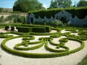 Castillo de Ainay-le-Vieil - Cartuja de Montreuils: jardín con parterres de broderie, estatuas, flores blancas y enrejados