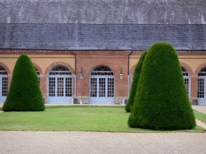 Castillo de Bouges - Frente de la Orangerie y arbustos podados, en la ciudad Bouges-le-Chateau