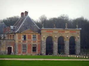 Castillo de Vaux-le-Vicomte - Común (dependencias) de ladrillo y pórtico de piedra y césped