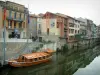 Castres - The River Agout with a wooden boat moored to the quay and houses reflected in water