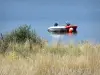 Meer van Cébron - Bootjes op het water, wilde bloemen en hoog gras op de voorgrond