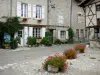 Charroux - Facciate di case e decorazioni floreali (fiori) di Rue de l'Horloge, nel Bourbonnais