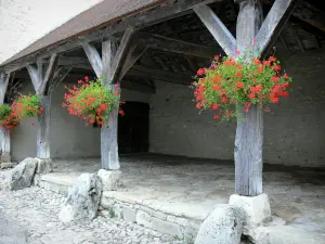 Charroux - Halle aux piliers de bois ornés de géraniums (fleurs)