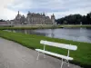 Château de Chantilly - Park: French-style formal garden of Le Nôtre: bench in foreground, La Manche, lawns and château