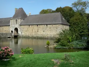Château de Gratot - Poterne d'entrée (porche d'entrée) et communs, pont, douves, arbres et pelouse