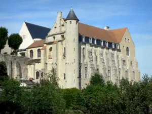 Château-Landon - Bâtiment conventuel de l'ancienne abbaye royale Saint-Séverin avec sa tour et ses contreforts, arbres en contrebas