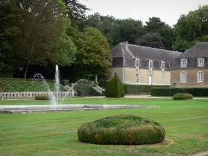 Château de la Lorie - Garden featuring a fountain and water jets, outbuildings and wing of the Château, trees, in Chapelle-sur-Oudon