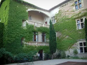 Château de Mauriac - Cour intérieure du château avec table, chaises et façade recouverte de lierre