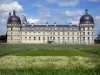 Château de Valençay - Facade of Classical style, corner towers of the château, and patchwork of meadow flowers of the park; clouds in the blue sky