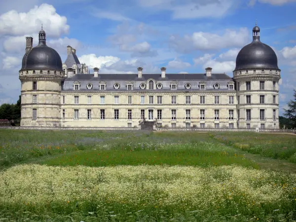 Château de Valençay - Facade of Classical style, corner towers of the château, and patchwork of meadow flowers of the park; clouds in the blue sky