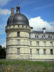 Château de Valençay - Corner tower and facade of the Classical-style château, patchwork of meadow flowers of the park; clouds in the blue sky