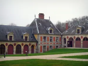 Château de Vaux-le-Vicomte - Dépendances (communs) en brique et pierre, et allées bordées de pelouses