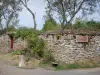 Châteauneuf - Mit Blumen geschmückte Steinmauer mit Wegweisern