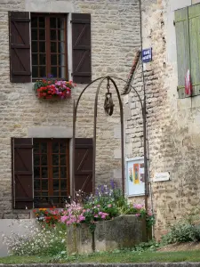 Châteauvillain - Mit Blumen geschmückter Brunnen und Fassaden der mittelalterlichen Kleinstadt