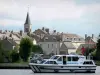 Châtillon-en-Bazois - Leisure boat sailing on the Nivernais canal, bell tower of the Saint-Jean-Baptiste church and houses of the village