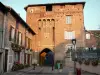 Châtillon-sur-Chalaronne - Porte de Villars gate (remains of ancient fortifications) and facades of houses with flowers 