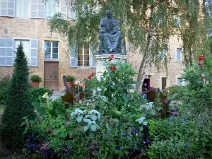 Châtillon-sur-Chalaronne - Standbeeld van St. Vincent de Paul, bloem bed (bloem) en de gevel van de voormalige Ursulinen klooster