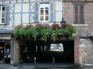 Châtillon-sur-Chalaronne - Facade of a timber-framed house, and flower-bedecked entrance of the covered market hall 