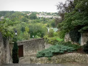 Chauvigny - Murs en pierre et arbres avec vue sur le plan d'eau du jardin public