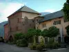 Ciudad medieval de Conflans - Great Place Garella flores con una fuente, flores, árboles, casas y casas del Museo Casa Roja de Etnografía e Historia