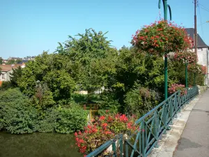 Civray - Flower-covered bridge spanning the Charente river, trees and houses of the city