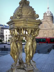 Clermont-Ferrand - Caryatids of the Wallace fountain, Jaude square, dome of the Saint-Pierre-les-Minimes church and tram in the background