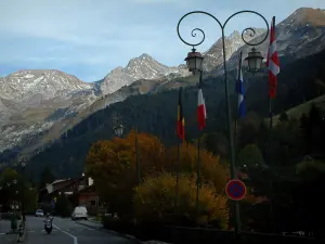 La Clusaz - Avenue Station (dorp) met zijn lampen en vlaggen, bomen met herfstkleuren, bossen en Aravis