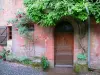 Collonges-la-Rouge - Front door of a stone building with a flowering wisteria