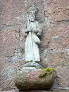 Collonges-la-Rouge - Pequeña estatua de un peregrino de Saint-Jacques en la fachada de la casa del peregrino