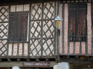 Cologne - Bastide : façades de maisons à colombages et panneau du syndicat d'initiative de Cologne