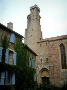 Cordes-sur-Ciel - Maison en pierre recouverte de lierre avec des volets bleus et église Saint-Michel