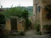 Cordes-sur-Ciel - Türchen eines Gartens und Häuser der mittelalterlichen Stätte mit Blick auf die umliegenden Hügel