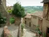 Cordes-sur-Ciel - Narrow paved streets and houses of the medieval town with view of the surroundings