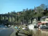 Dinan - Porto con yacht e barche, ponte sul fiume, case, alberi e muri del centro storico che domina l'intero