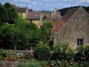 Domme - Flores en el primer plano y casas de la casa de campo en el valle de la Dordogne, en Périgord